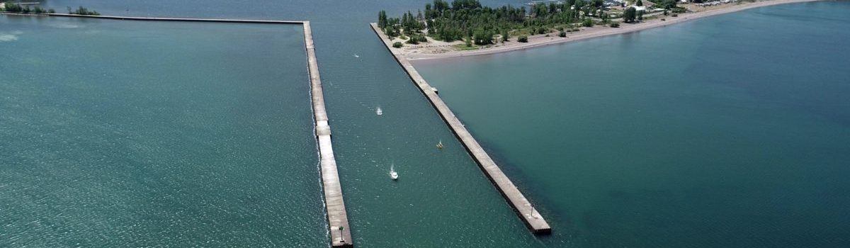 Aerial view of Fair Haven, NY, Cayuga County, and Little Sodus Bay seawall and channel with boats